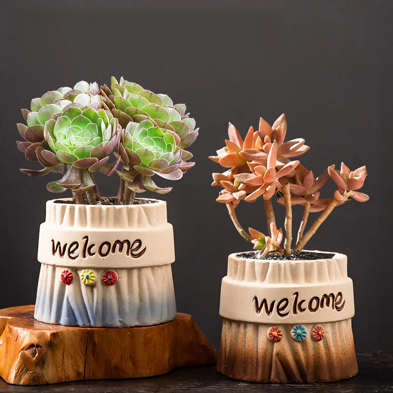 Two tree stump ceramic planters with welcome text and dimensions displayed