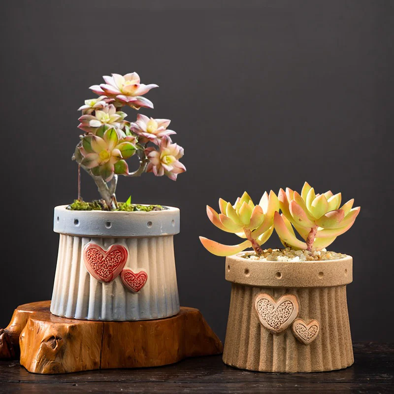 Two ceramic planters with embossed hearts and dimensions displayed