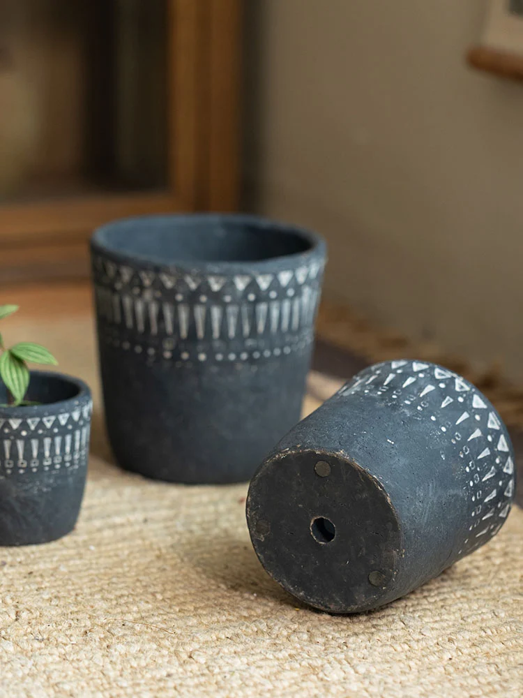Vintage dark gray concrete planter showing bottom drainage hole