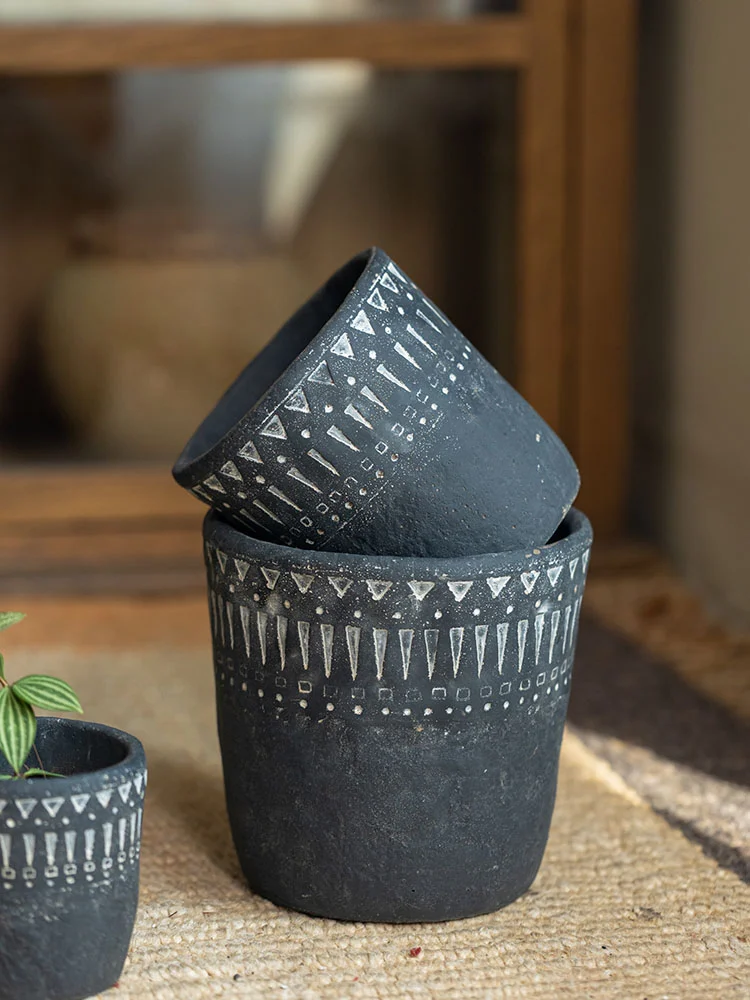 Stacked dark gray concrete planters with white patterns