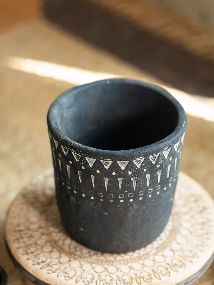 Empty dark gray concrete planter on a wooden coaster