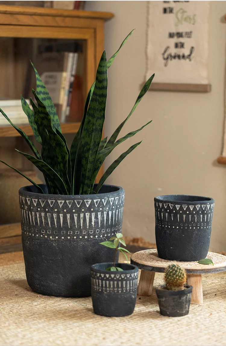 Multiple dark gray concrete planters in different sizes