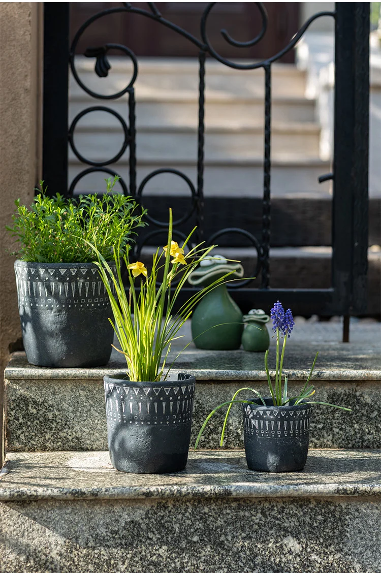 Dark gray concrete planters on stone steps outdoors